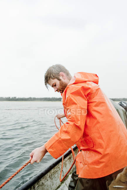 Man fishing in sea, focus on foreground — Stock Photo