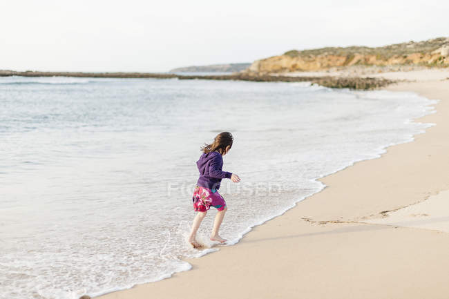 Ragazza che corre nel surf ad Alantejo, Portogallo, attenzione differenziale — Foto stock