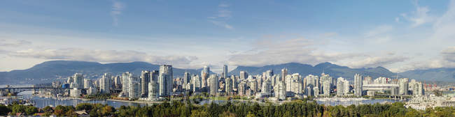 Paisaje urbano de Vancouver con colinas y exuberante vegetación a la luz del sol - foto de stock