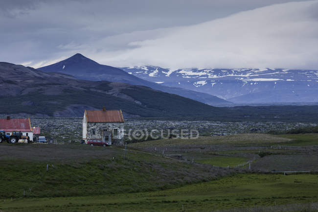 Pueblo de montaña con casas antiguas y vistas a los picos nevados - foto de stock