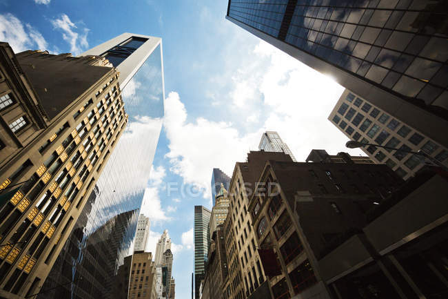 Vista hacia arriba de los rascacielos contra el cielo en Manhattan, Nueva York - foto de stock