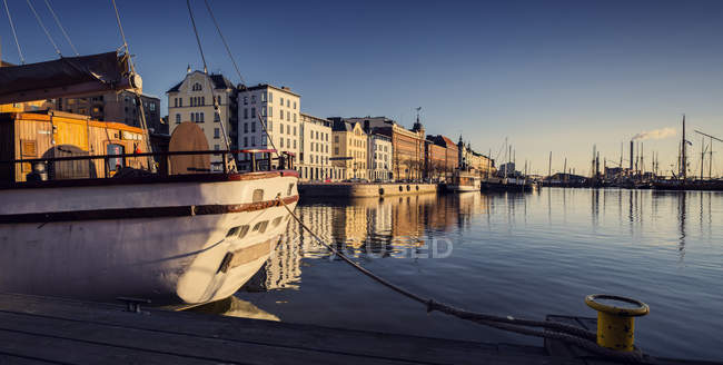 Case portuali che si riflettono in acqua e yacht ormeggiato alla luce del sole — Foto stock
