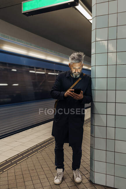 Mann schreibt SMS am Bahnhof — Stockfoto
