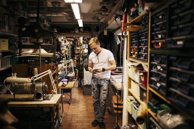 Hombre maduro que trabaja en taller de cuero - foto de stock