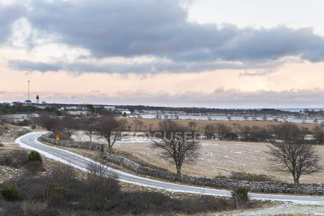 Empty road with village in background, northern europe — Stock Photo