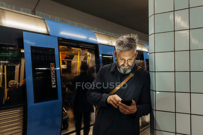 Mann schreibt SMS am Bahnhof — Stockfoto