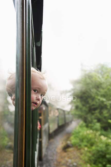 Ragazzo guardando attraverso la finestra del treno — Foto stock