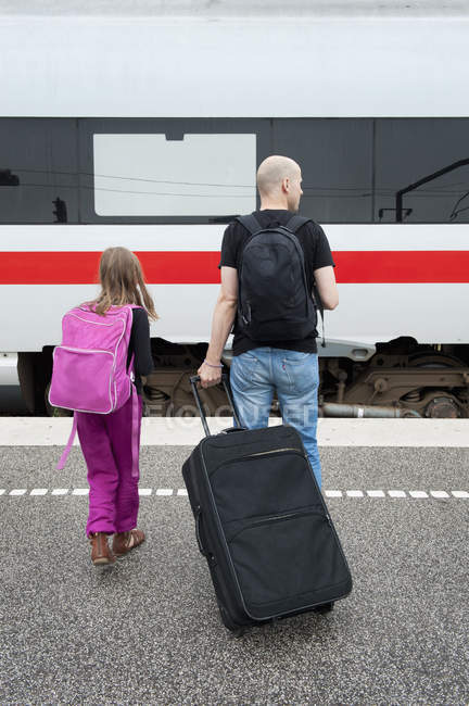 Отец и дочь стоят на платформе железнодорожного вокзала — стоковое фото
