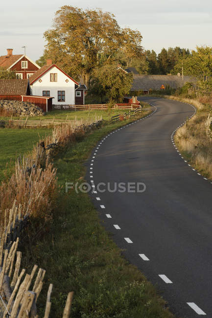 Scenic view of houses along rural road — Stock Photo