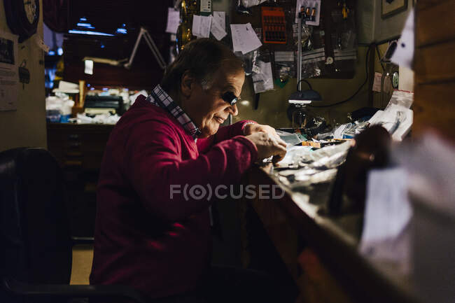Чоловік ремонтує годинник у майстерні — стокове фото
