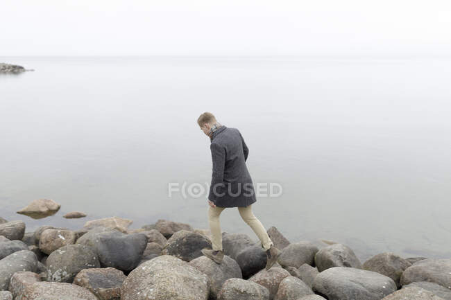 Uomo che cammina sulla costa rocciosa, vista ad alto angolo — Foto stock