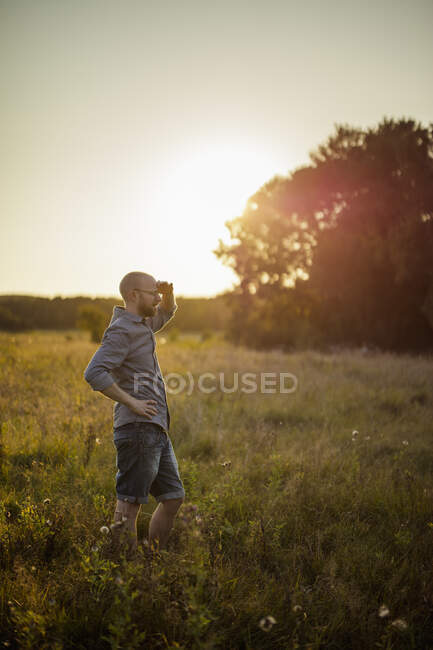 Вид сбоку взрослого мужчины средних лет, стоящего на поле — стоковое фото