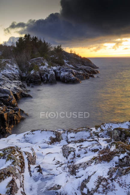 Vista panorámica de la costa rocosa cubierta de nieve - foto de stock