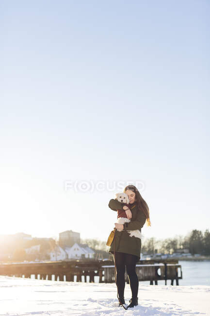 Jeune femme avec son chien pendant l'hiver — Photo de stock