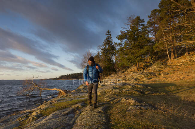 Man walking along coastline — Stock Photo