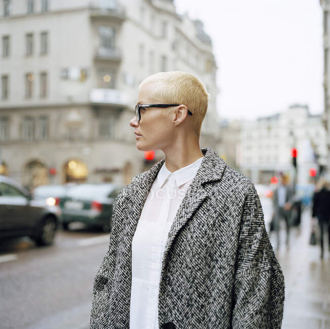 Mulher adulta média de pé na rua da cidade olhando para longe — Fotografia de Stock