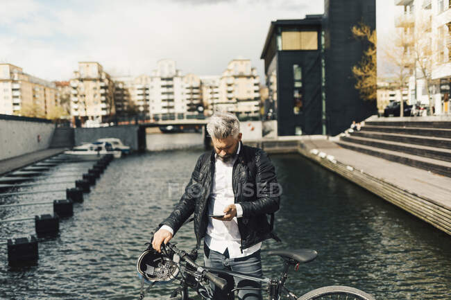 Мужчина на смартфоне с велосипедом в Стокгольме, Швеция — стоковое фото