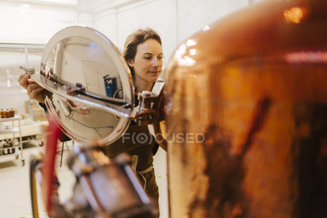 Sorrindo jovem trabalhador feminino em gin destilaria — Fotografia de Stock