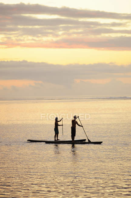 Männer paddeln bei Sonnenaufgang in Bora Bora — Stockfoto