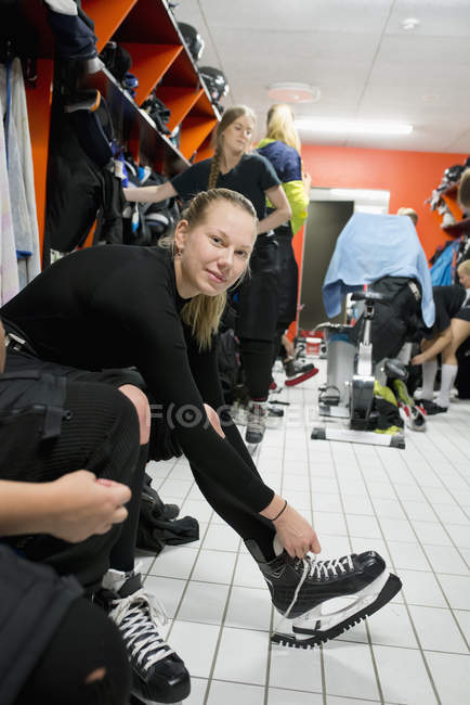 Young ice hockey players getting ready in locker room, selective focus — Stock Photo