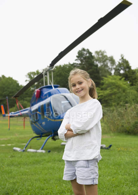 Portrait de fille regardant la caméra avec hélicoptère en arrière-plan — Photo de stock