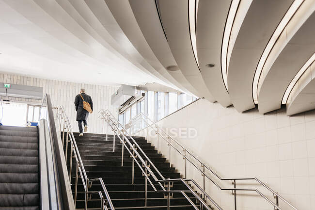 Uomo che cammina su scala di edificio moderno a Stoccolma, Svezia — Foto stock
