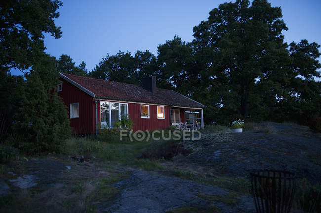 Casa illuminata rossa al tramonto, Svezia — Foto stock