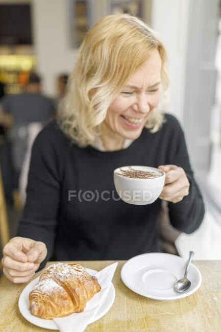 Smiling woman at cafe in England — Stock Photo