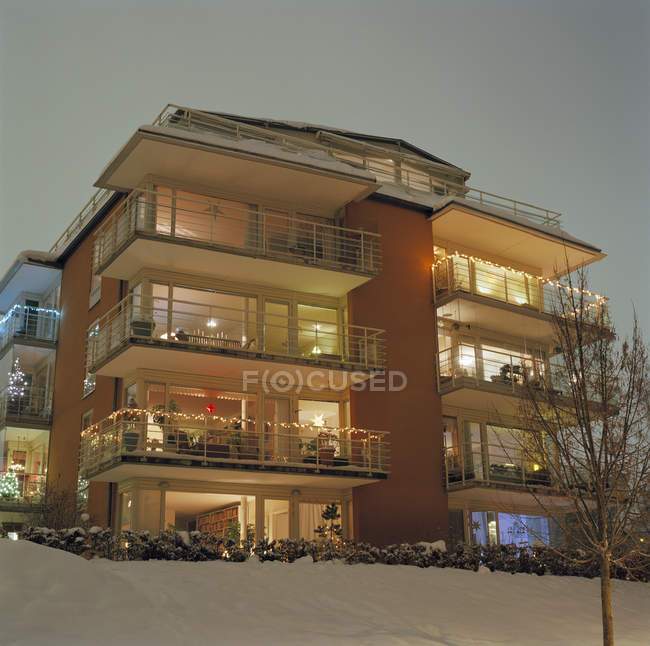 Фасад светлого жилого дома с рождественскими украшениями зимой — стоковое фото