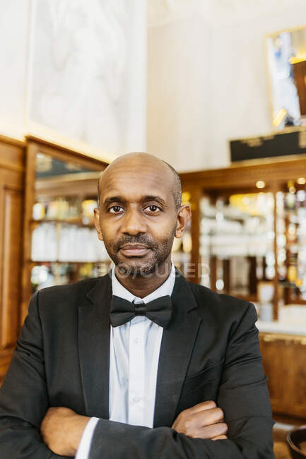 Waiter at bakery standing with crossed arms and looking at camera — Stock Photo