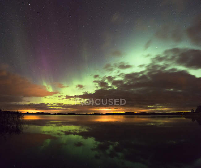 Aurora borealis and clouds reflecting in water — Stock Photo