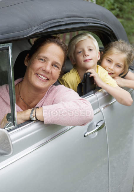 Madre e hijos en coche, enfoque selectivo - foto de stock