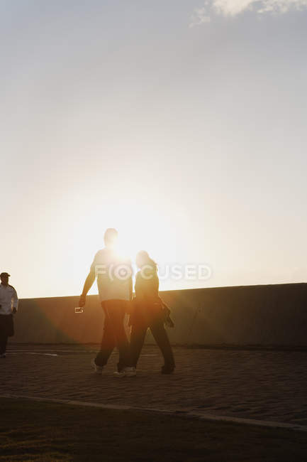 Пара держащихся за руки во время ходьбы, избирательный фокус — стоковое фото