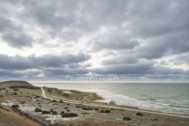 Vista panorámica del camino vacío por mar al atardecer - foto de stock