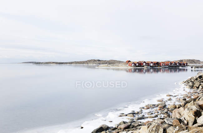 Wooden houses and rocky coastline in winter — Stock Photo
