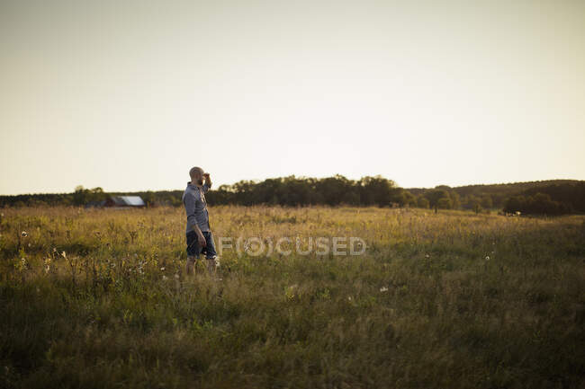 Vista lateral do homem adulto médio em pé no campo — Fotografia de Stock