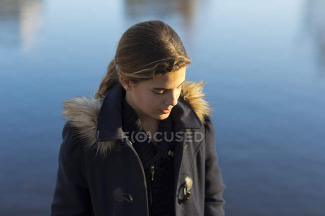 Portrait of teenage girl by water, focus on foreground — Stock Photo