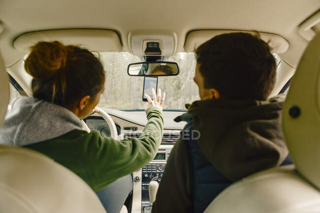 Couple in car getting directions on smart phone — Stock Photo