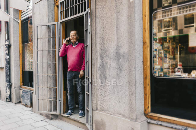 Man talking on phone at storefront — Stock Photo