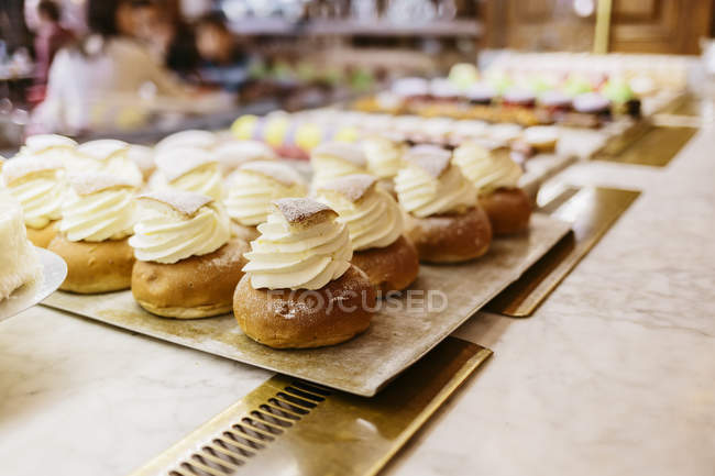 Creamed eclairs at bakery, focus on foreground — Stock Photo