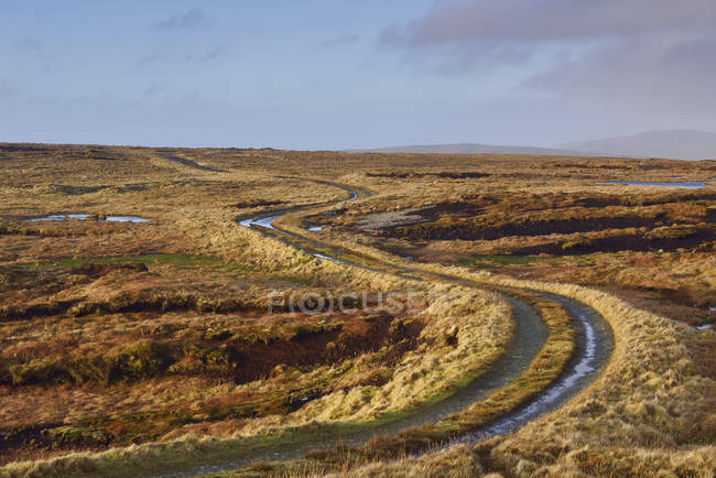 Strada rurale sotto il cielo con nuvole nelle Shetland, Scozia — Foto stock