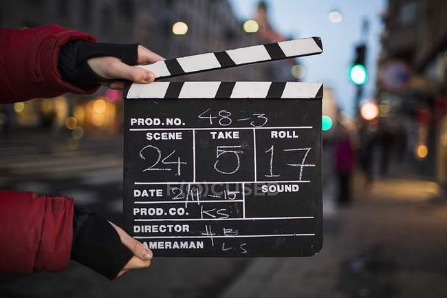 Female hands holding film slate, focus on foreground — Stock Photo