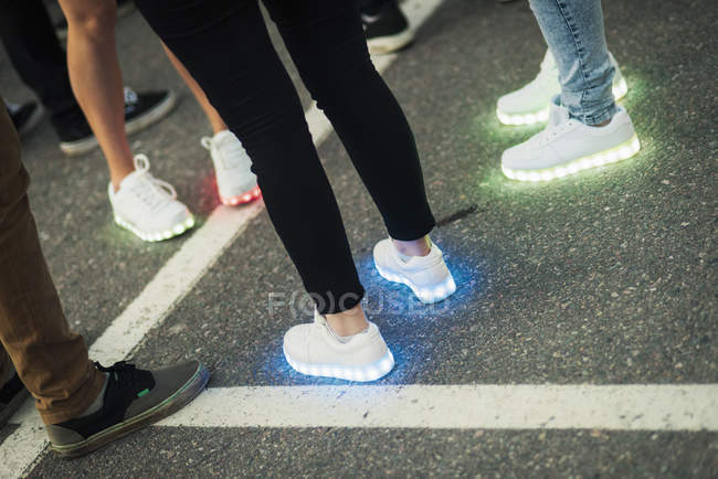 Люди в кроссовках с светящимися подошвами — стоковое фото
