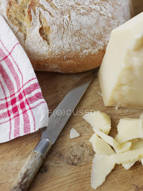 Queijo parmesão e pão sobre tábua de corte, seletivo — Fotografia de Stock