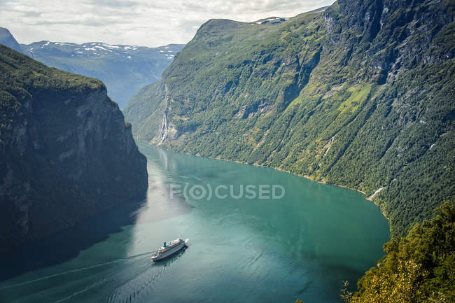 Malerischer Blick auf das Schiff, das durch die Berge im Geirangerfjord segelt — Stockfoto