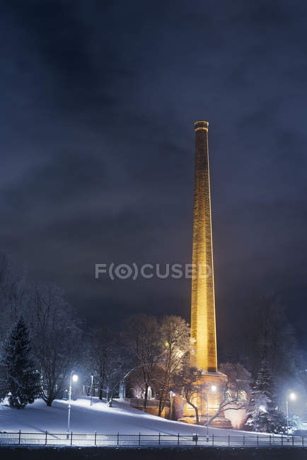 Illuminated tower of factory at night, northern europe — Stock Photo