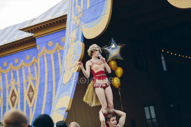 Female acrobat balancing on male acrobat on stage — Stock Photo