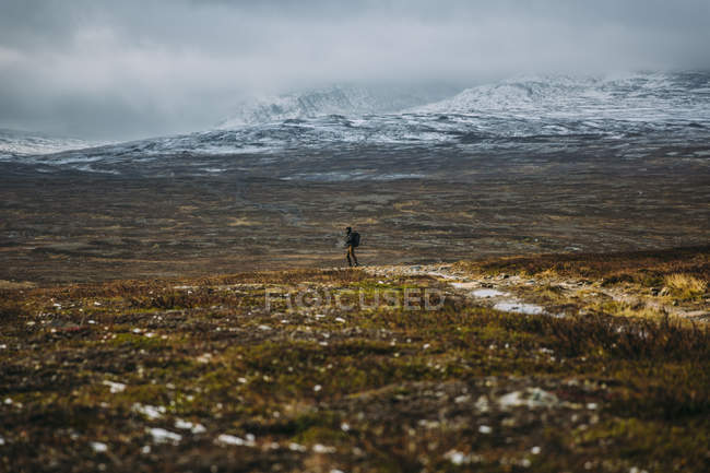 Человек, идущий в горы, избирательный фокус — стоковое фото