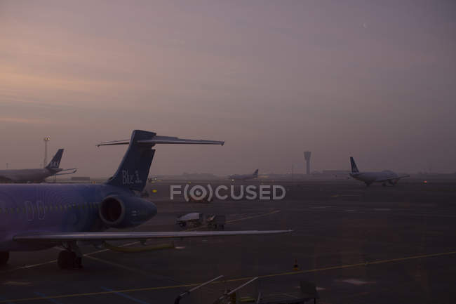 Aviones en el aeropuerto al atardecer, norte de Europa - foto de stock