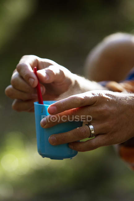 Mains masculines tenant tasse en plastique — Photo de stock